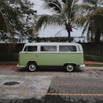 Green Volkswagen Transporter Van Parked Under Coconut Trees